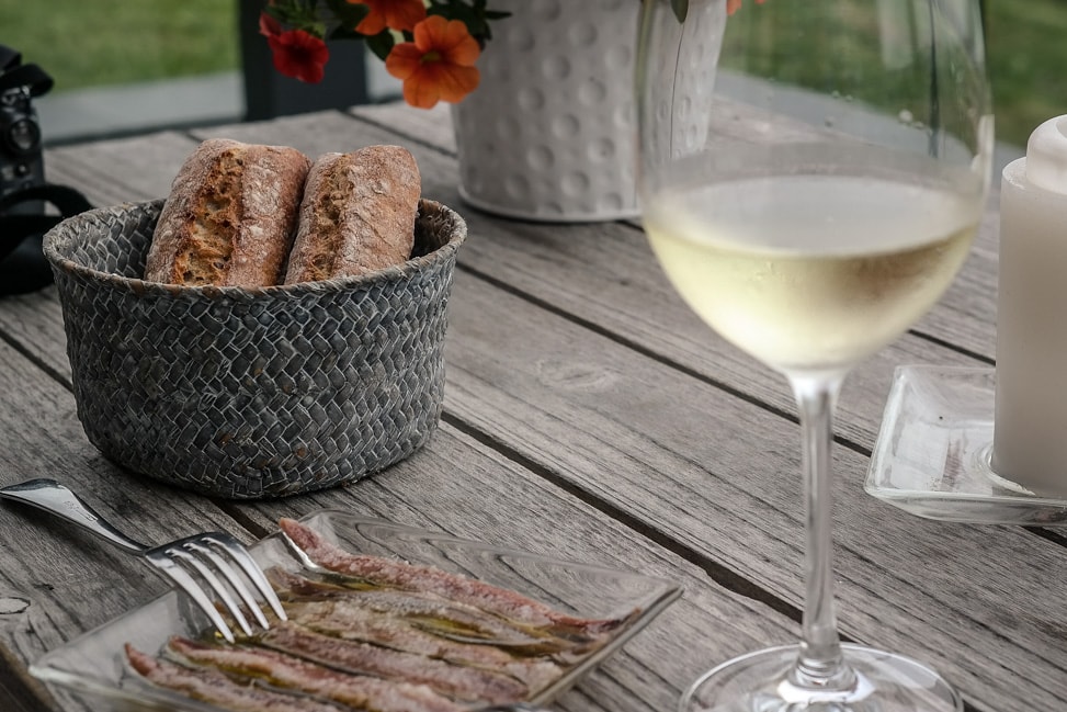 a plate of anchovies, bread, and glass of txakoli wine at the Hotel San Prudentzio in Getaria, Spain