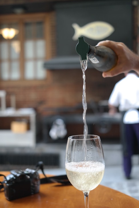 Pouring a glass of txakoli while eating pintxos in San Sebastian