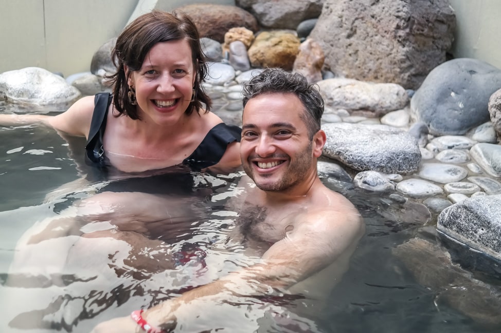 julie and drew soak in the mineral hot springs near rotorua